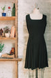 Women's knee length flared dress in black with a square neckline and long sleeves in a jersey knit.
